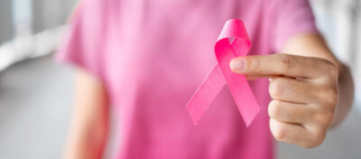 October Breast Cancer Awareness month, Woman in pink T- shirt with hand holding Pink Ribbon for supporting people living and illness. Healthcare, International Women day and World cancer day concept