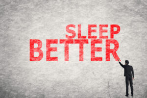 man pointing at sign "sleep better"