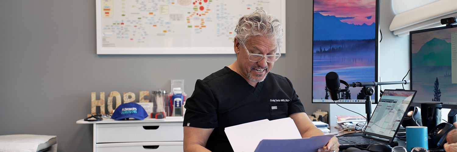 Dr. Tanio reviewing brain health paperwork at his desk