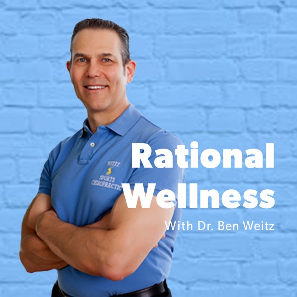 Dr. Ben Weitz, arms crossed, in front of a blue brick wall