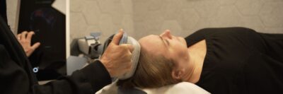 Nurse holding Exomind TMS device to users head